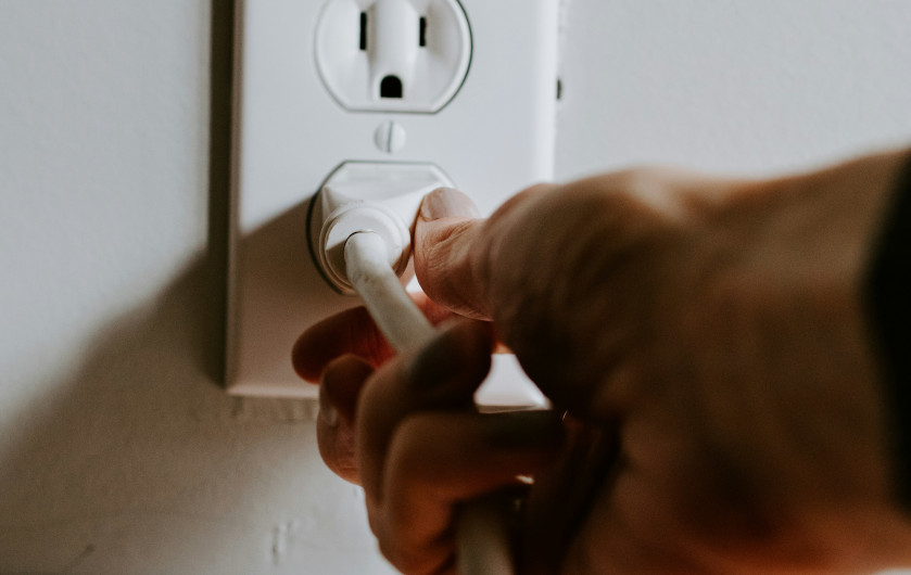 hand plugging a power cord into an outlet