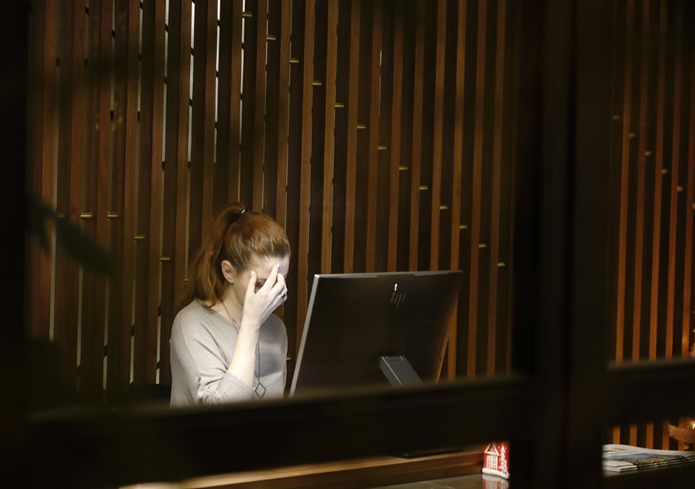 Woman at a computer with a headache